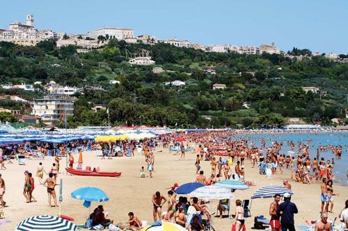 una multitud de personas en una playa con sombrillas en Villetta Lena al Mare, en Vasto