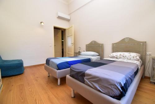 ピエトラサンタにあるAppartamento a 150M dal Duomoのベッドルーム1室(ベッド2台、青い椅子付)