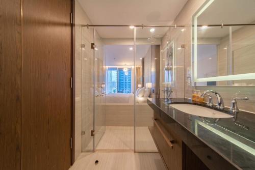 a bathroom with a sink and a glass shower at CoolSea Panorama Superview Nha Trang Apartment in Nha Trang