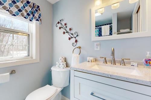 un bagno con un water, un lavandino e una finestra di Mabel's Maine Cottage a Boothbay Harbor