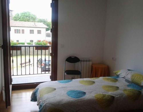 a bedroom with a bed with a view of a balcony at Ultzama in Iráizoz