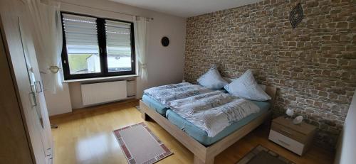a bedroom with a brick wall and a bed at Haus Maria in NeuhÃ¼tten