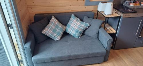 威廉堡的住宿－Neptune's Rest，一张蓝色的沙发,上面有两个枕头