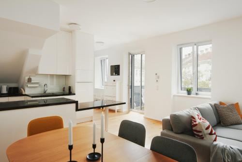 cocina y sala de estar con mesa en New Spacious Ultra-Modern Apartment in Wien Westbahnhof en Viena