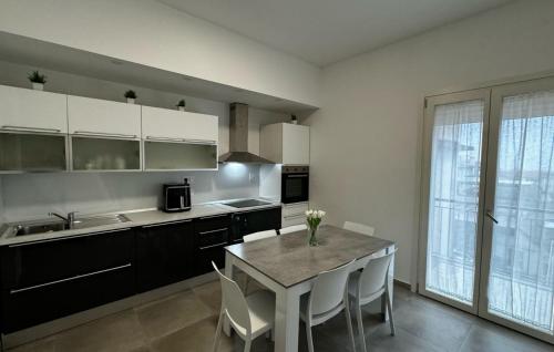 a kitchen with a table and white cabinets and a table and chairs at B&B Campo Sportivo in Taurianova