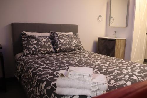 a bedroom with a bed with towels on it at AMR Hotel Inc in Saint-Jérôme