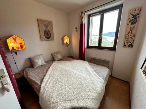 une petite chambre avec un lit et une fenêtre dans l'établissement Joli 2 pièces, vue montagne, balcon Sud, WIFI, kit bébé - FR-1-515-181, à Villard-de-Lans
