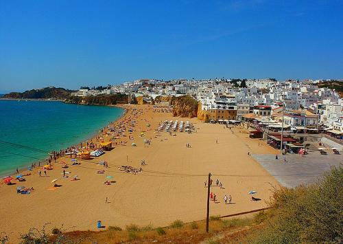 a group of people on a beach with the ocean at Casa dos Sinos 2Bedroom Beach Apartment with Terrace in Albufeira