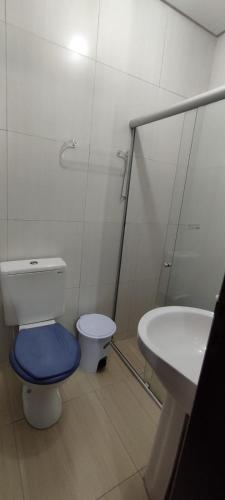 a bathroom with a toilet with a blue seat and a sink at AP AO LADO DO PÁTIO DO FORRÓ e EVENTOS in Caruaru