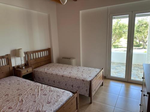 a bedroom with two beds and a large window at The Saint George in Mastichari