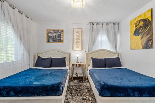 two beds in a bedroom with blue sheets at villa venezia bb in Miami Beach
