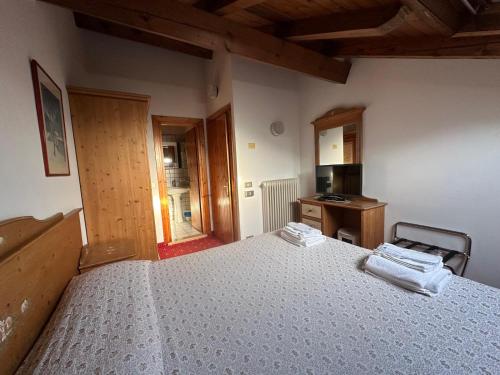 um quarto com uma cama, uma secretária e uma cozinha em Hotel Alpi - Foza em Foza