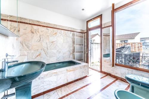 La salle de bains est pourvue d'une baignoire et d'une fenêtre. dans l'établissement maison chalet conviviale, à Aubervilliers