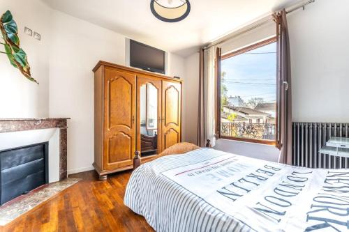 - une chambre avec un lit, une commode et une cheminée dans l'établissement maison chalet conviviale, à Aubervilliers