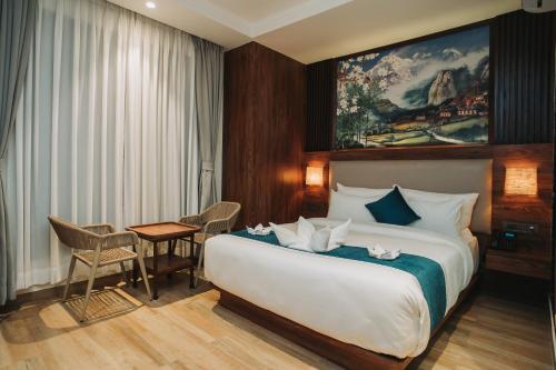 ein Hotelzimmer mit einem großen Bett und einem Tisch in der Unterkunft Dees Boutique Hotel in Kathmandu