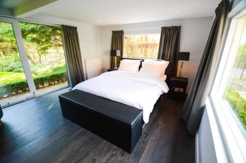 1 dormitorio con cama y ventana grande en Bed & Breakfast De Boogschutter - Kersenboom, en Langenboom