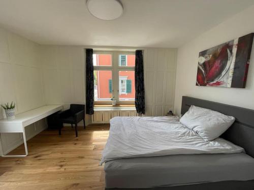 een slaapkamer met een bed, een bureau en een raam bij Modernes Appartement in Wald in Wald