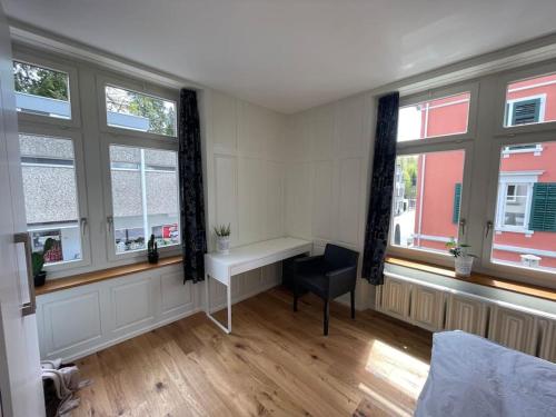 een slaapkamer met ramen en een bureau in een kamer bij Modernes Appartement in Wald in Wald