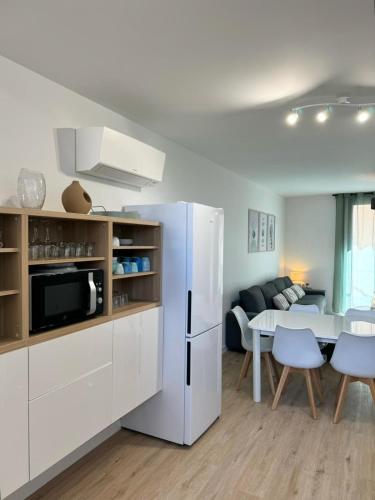 une cuisine avec un réfrigérateur blanc et une table dans l'établissement Panorama du Vallespir, à Maureillas