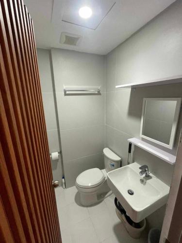 a bathroom with a white toilet and a sink at Twin Hearts Residences Unit 215 in Roxas City