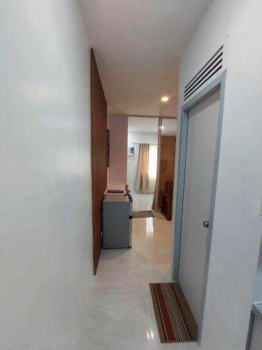 a room with a hallway with a refrigerator and a door at Twin Hearts Residences Unit 215 in Roxas City