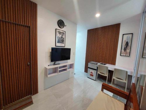 sala de estar con TV y mesa con sillas en Twin Hearts Residences Unit 215 en Roxas City