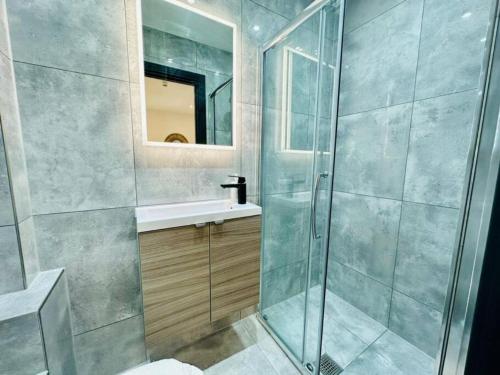 uma casa de banho com um chuveiro, um lavatório e um espelho. em Kingsize Bed By sea/central em Brighton & Hove