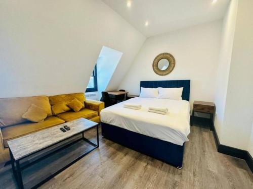 um quarto com uma cama e um sofá em Kingsize Bed By sea/central em Brighton & Hove