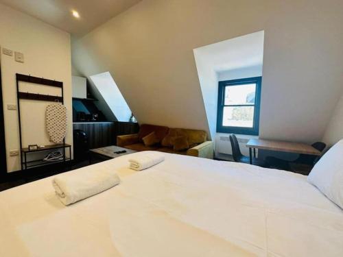 um quarto com uma grande cama branca e uma sala de estar em Kingsize Bed By sea/central em Brighton & Hove