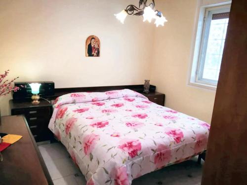 a bedroom with a bed with pink flowers on it at Charming Villa in Monreale with Private Pool in Pioppo
