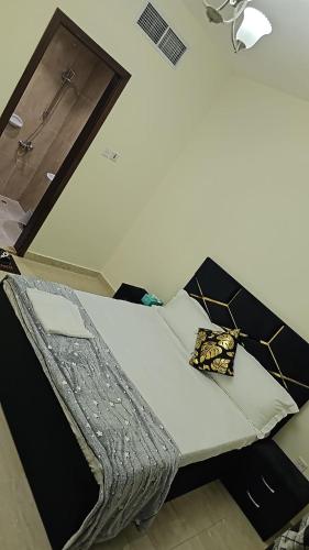 Bett in einem Zimmer mit weißem Bettgitter in der Unterkunft Luxury Rooms in Dubai