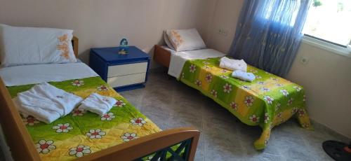 a small bedroom with two beds and a table at Mihalis Vrion Apartment in Vrion