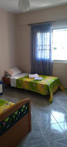 two beds in a room with a window at Mihalis Vrion Apartment in Vrion
