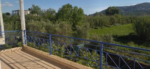 a blue railing on a balcony with a view of a field at Mihalis Vrion Apartment in Vrion