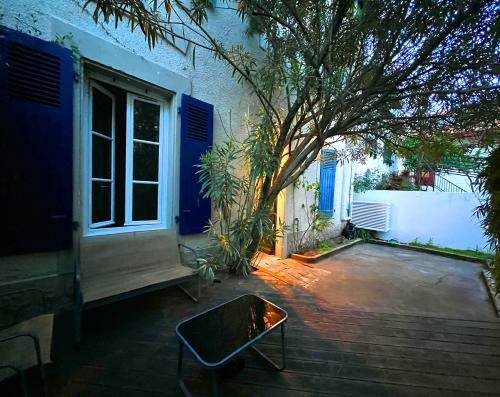 un patio con un árbol frente a una casa en Etxea Zoriontsua, en Biarritz