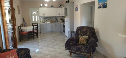 a kitchen and living room with two chairs and a table at Mihalis Vrion Apartment in Vrion