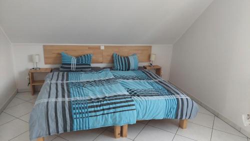 um quarto com uma cama com lençóis azuis e brancos em Ferienwohnung Begau em Alsdorf