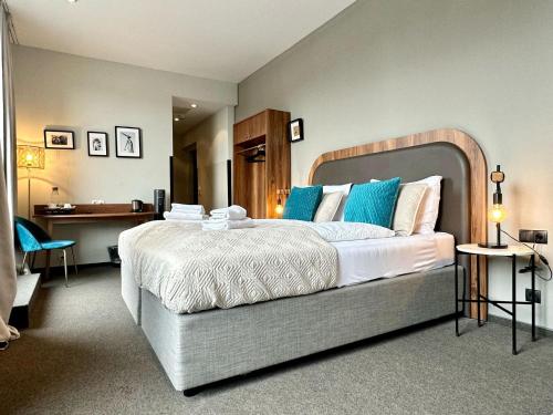 a bedroom with a large bed with blue pillows at Hotel George Vienna in Vienna