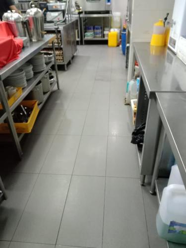 a kitchen with white tile flooring in a store at Peace Ghor in Kuala Lumpur