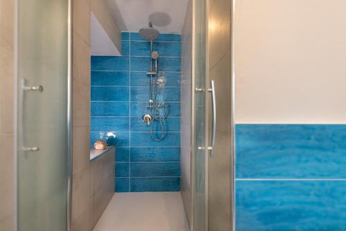 a bathroom with a shower with blue tiles at Dimore di mare - Beachfront Apartments in Santa Flavia