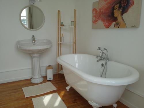 a bathroom with a sink and a bath tub next to a sink at Charme D Antan in Villers-Châtel
