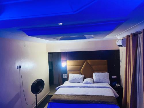 una camera con un letto e un soffitto blu di Havilah Suites Ltd, Nnewi a Nnewi