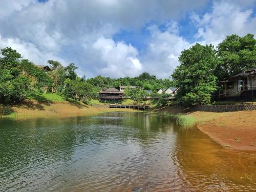 une masse d'eau avec des maisons en arrière-plan dans l'établissement Sofia's Lake Resort, à Cavinti