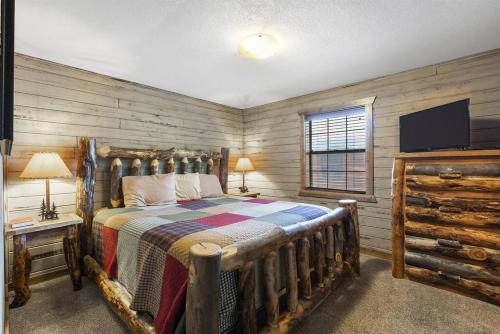 1 dormitorio con 1 cama en una habitación con paredes de madera en Lake Front Cabin on Indian Point, en Branson