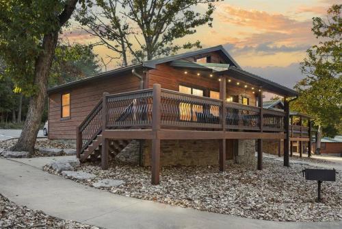 a large wooden house with a large deck at Lake Front Cabin on Indian Point in Branson
