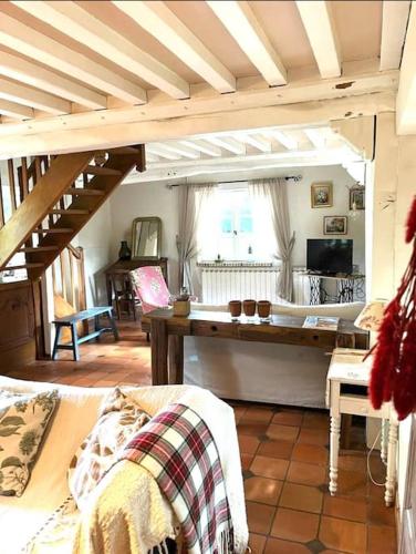 un salon avec un canapé et une table dans l'établissement Chaumière normande et sa dépendance, proche Deauville et Honfleur 10-12 pers, à Quetteville