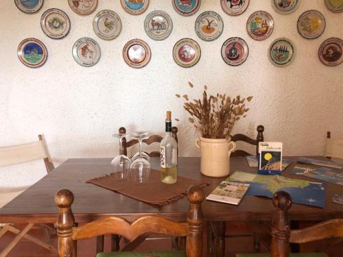 a dining room table with wine bottles and plates on the wall at Villa Liliana P9275 in Torre delle Stelle