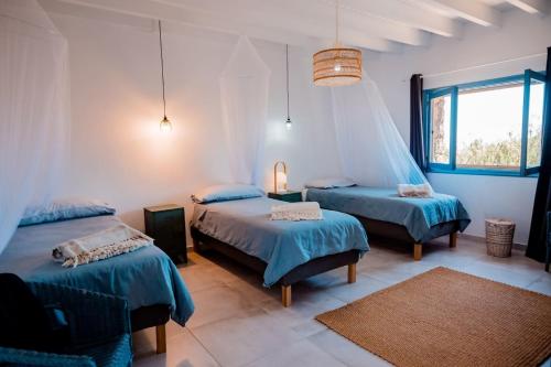 a bedroom with three beds and a window at Ecovilla Haleakala con Piscina y Sauna privadas in Villaverde