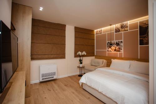 a bedroom with a bed and a chair at Oro Inn Hotel in Shkodër