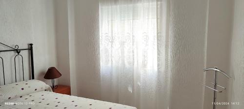 a bedroom with a bed and a white curtain at Apartamento en Ciudad Jardín a 8 min Casco Historico in Córdoba